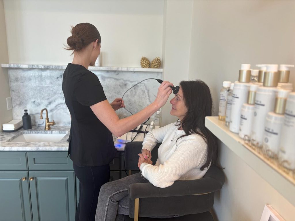 Esthetician performing a Skin Instant Lab consultation to read a client's skin before a Biologique Recherche treatment